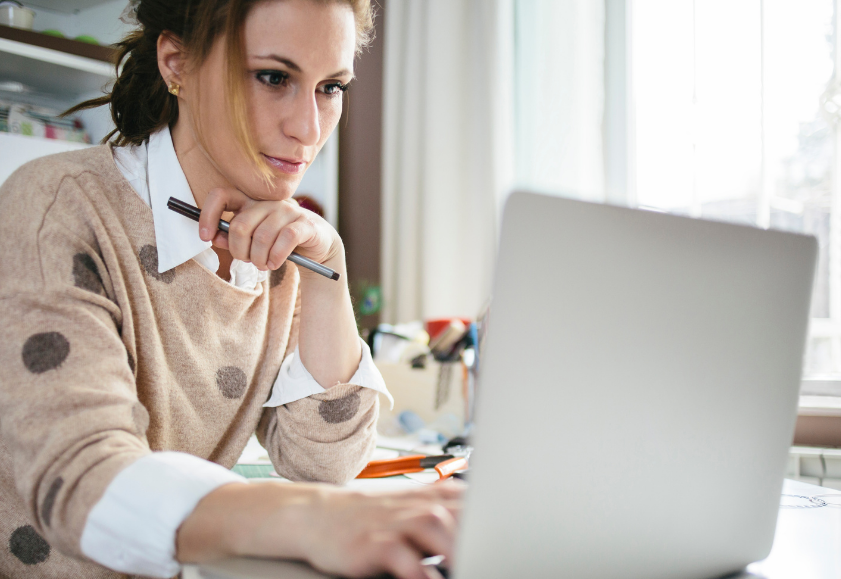 Small business owner reading an article on portable computer.