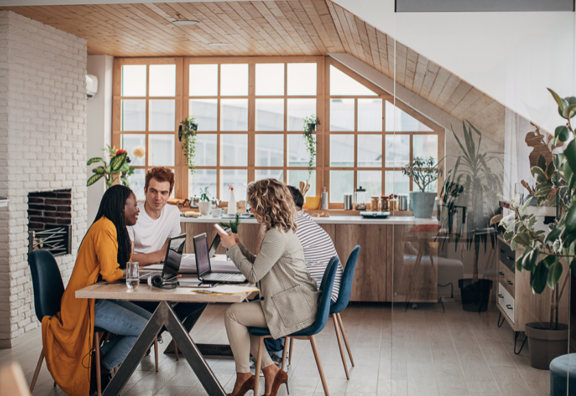 Men and women employees talking over documents in an office.
