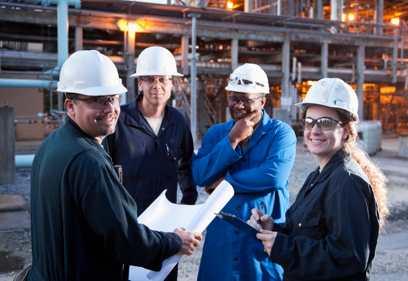 Group of manufacture workers in safety wear at a construction site